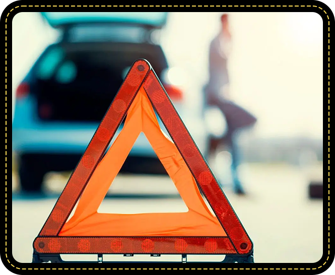 A red and orange triangle sign sitting in front of a car.