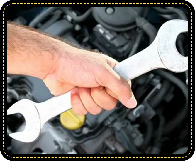 A person holding two wrenches in front of the engine.